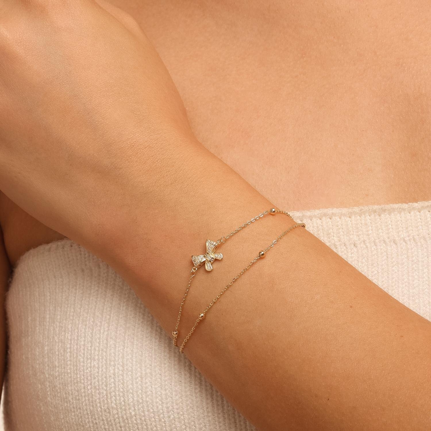 Pst-5660-Fo Pulseira Feminina com Pingente de Laço Cravejado e Esferas Douradas